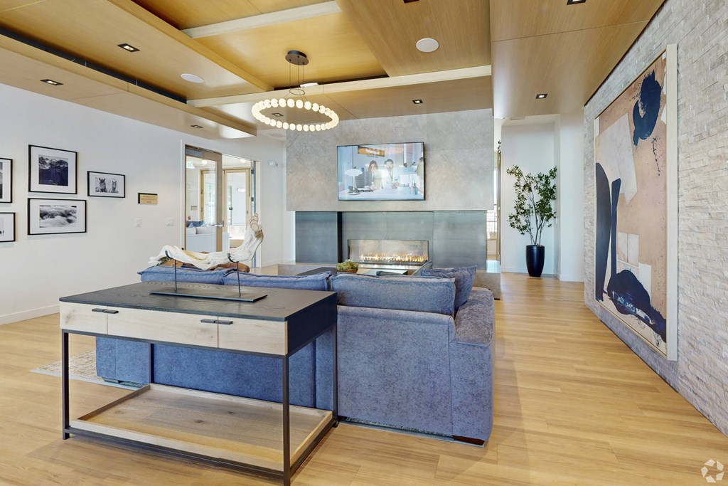 A woman is sitting on a couch in a modern living room.
