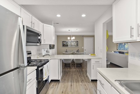 A modern kitchen with white cabinets and stainless steel appliances.
