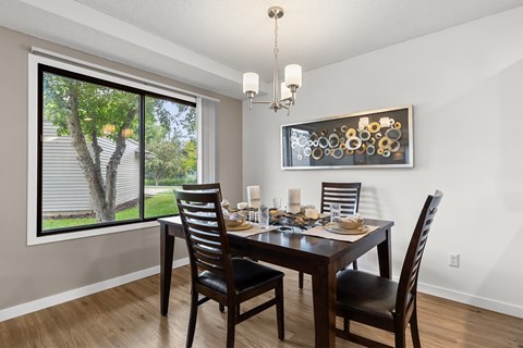 A dining room with a table set for two and a chandelier.