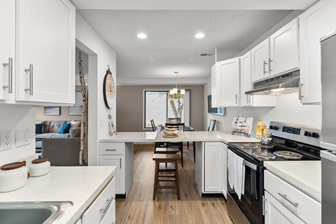 A modern kitchen with white cabinets and stainless steel appliances.