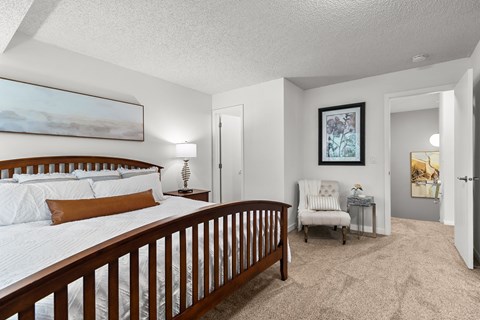 A bedroom with a large bed and a chair in it.