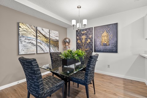 A dining room with a glass table and chairs.