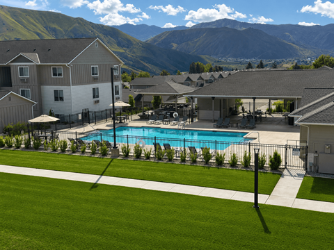A swimming pool in a backyard with a mountain in the background.