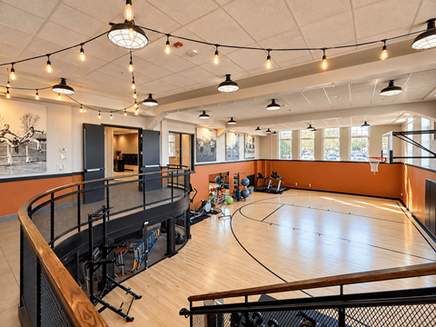 A basketball court inside a gym with a basketball hoop and a net.