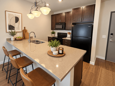 A kitchen with a black refrigerator and brown stools.