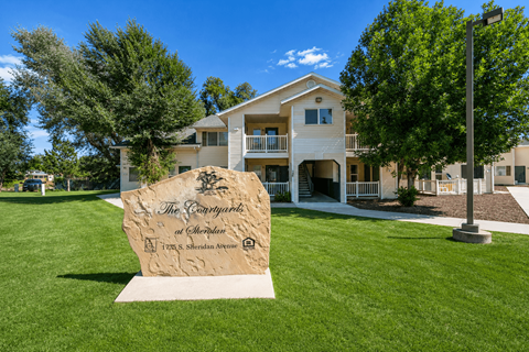 A large stone sign in front of a building that says "The Parkway".