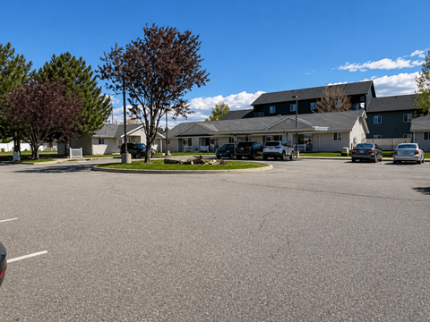 A parking lot with cars and a building in the background.