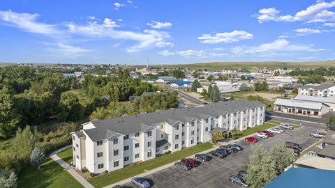 A large white building with a parking lot in front of it.