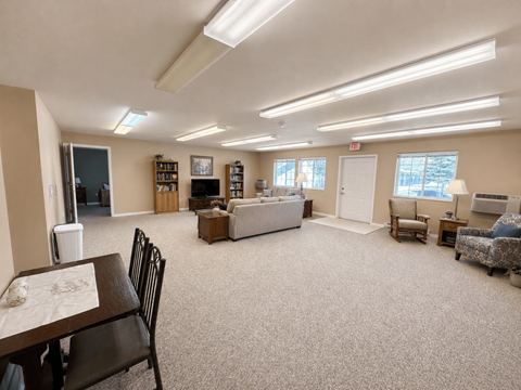 A spacious living room with a dining table and chairs.