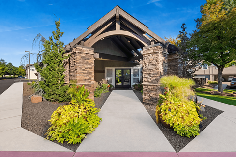 A building with a stone pillar entrance and a landscaped area in front.