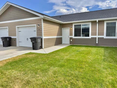 A house with a brown siding and a white door is shown.