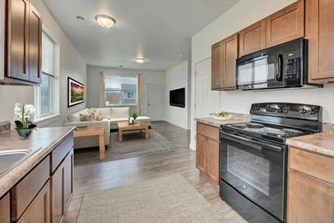 A kitchen with a black oven and microwave above it.