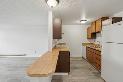A kitchen with a white refrigerator and wooden countertops.