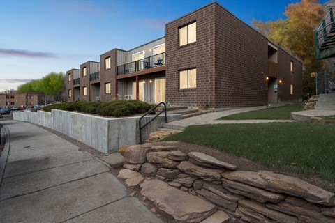 A modern brick building with a stone wall in front.
