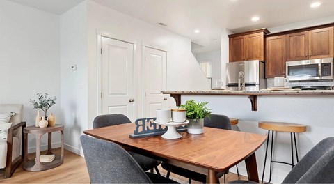 A modern dining room with a wooden table and grey chairs.