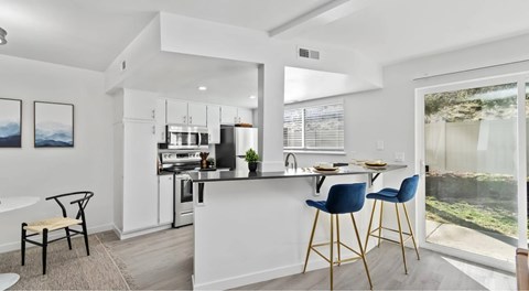 A modern kitchen with a dining table and chairs.