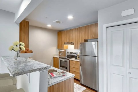 A kitchen with a marble table and a refrigerator.