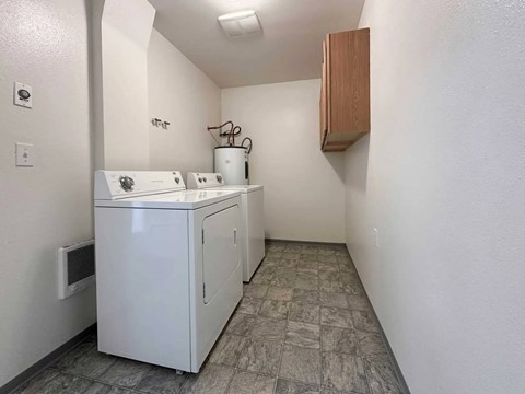 A small white kitchen with a sink and a cabinet.