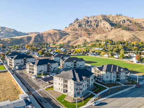 A mountainous landscape with a small town and apartment buildings in the foreground.