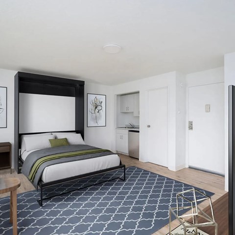 A bedroom with a large bed and a patterned carpet.