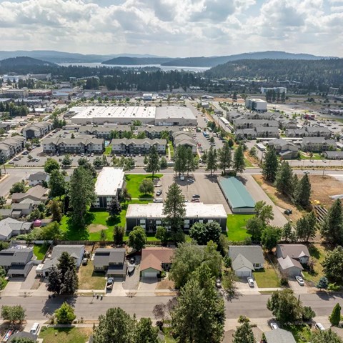 A bird's eye view of a residential area with houses, a large building, and a parking lot.