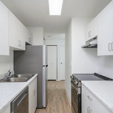 A kitchen with white cabinets and stainless steel appliances.