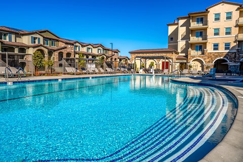 A large swimming pool in front of apartment buildings.