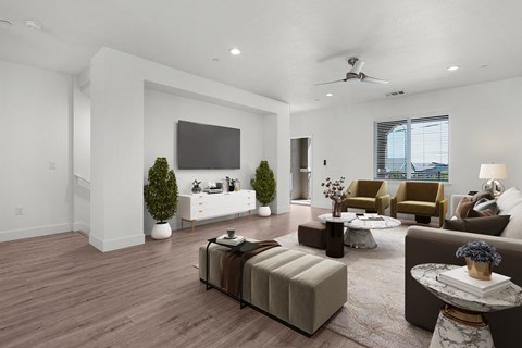 A living room with a brown sofa, a white couch, and a television on the wall.