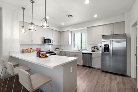 A modern kitchen with a white island and stainless steel appliances.