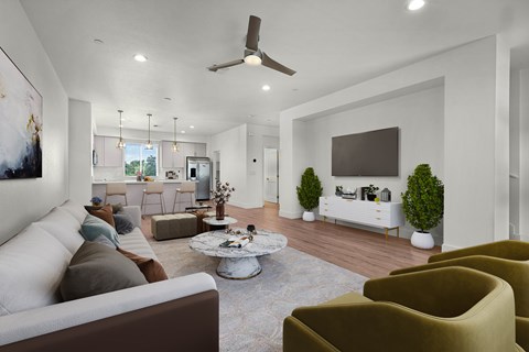 A living room with a white couch, a grey coffee table, and a brown armchair.