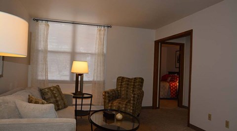 A living room with a couch, chair, and lamp.