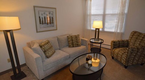 A living room with a couch, chair, and table.