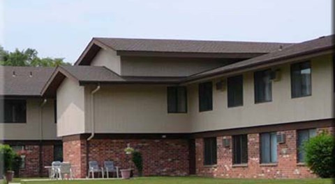 A house with a brown roof and a brick wall.