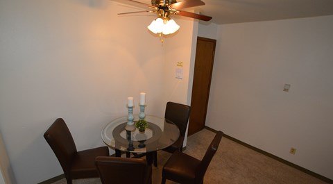 A dining room with a table and chairs.