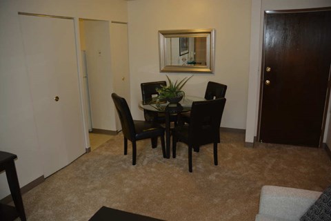 A dining room with a table and chairs.