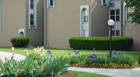 A building with a grey facade and a green lawn in front.