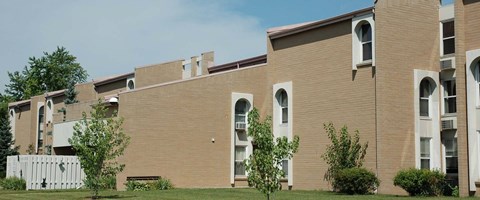A building with a brown facade and white trim.