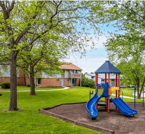 A playground with a blue slide and a red and yellow slide.