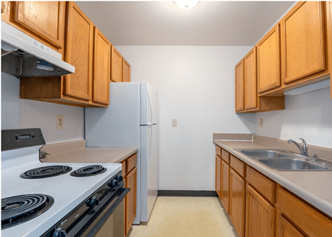 A kitchen with wooden cabinets and a white refrigerator.