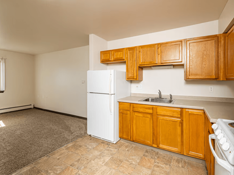 A kitchen with wooden cabinets and a white refrigerator.