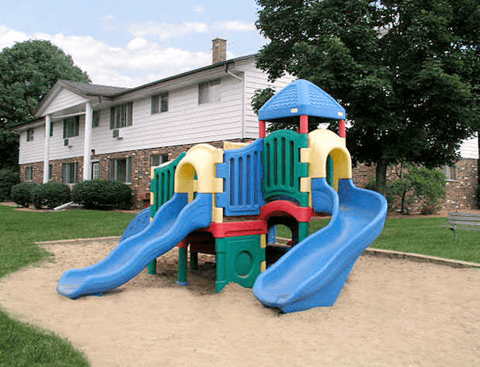 A playground with a blue slide and a red, green, and yellow structure.