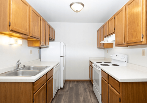 A kitchen with wooden cabinets and white appliances.