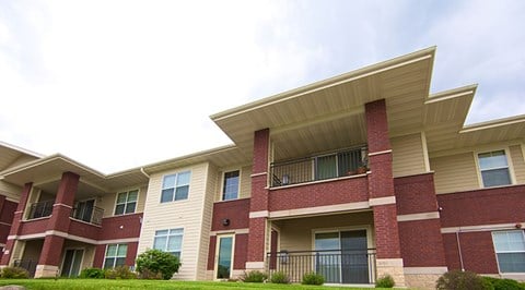 Apartment building with red brick and beige siding.