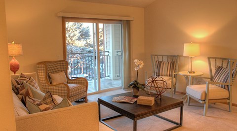A living room with a sofa, armchairs, and a coffee table.