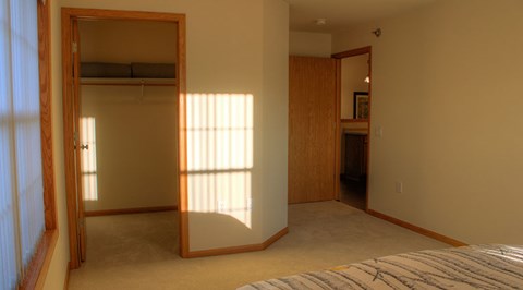 A bedroom with a large bed and a full-length mirror.