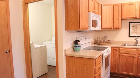 A kitchen with wooden cabinets and a white fridge.