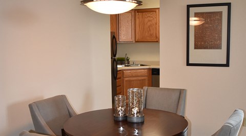 A dining room with a table and chairs.