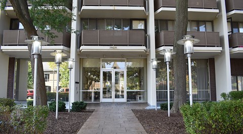 The image shows the front of a building with a glass door entrance and a sign that reads "SID".