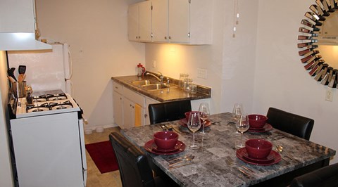 A kitchen with a table set for four.