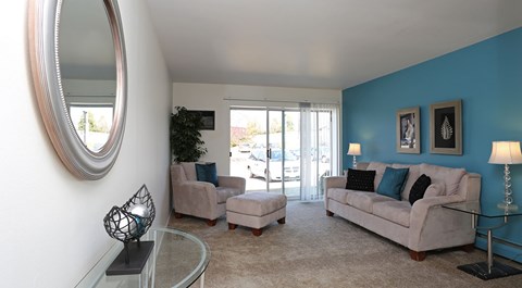 A living room with a white couch and a glass coffee table.
